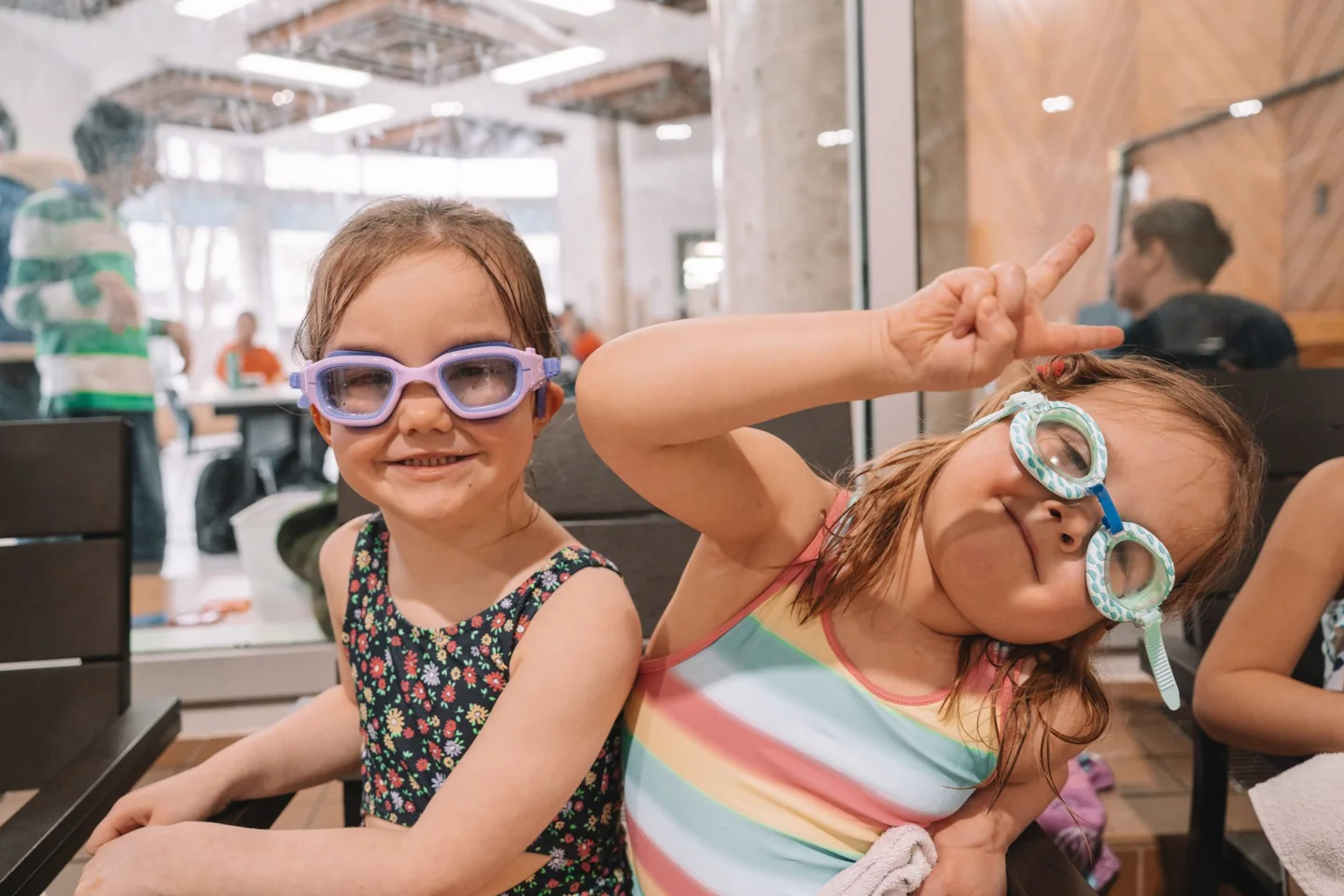 Two smiling children wear swimming goggles at Variety Village