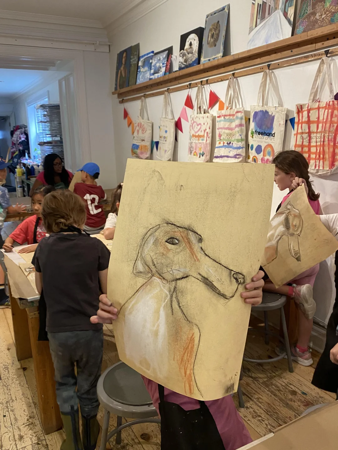 Children and a teacher work on a large drawing in an art studio