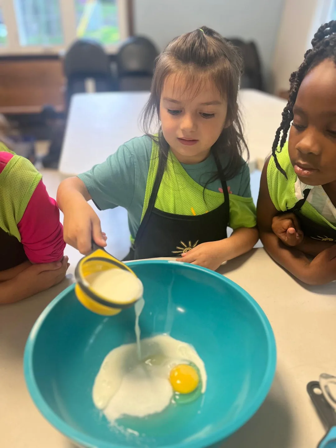 Children mix ingredients in a large bowl