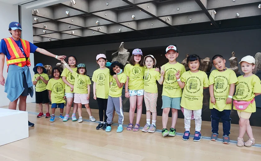 A group of children and staff pose during a camp outing