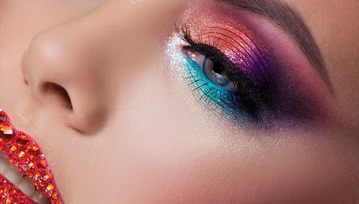 Close view of colourful eye makeup and decorative face gems