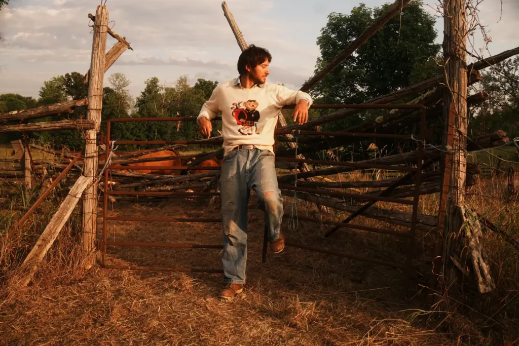 A model wears jeans and a printed shirt in an Exile Vintage photograph
