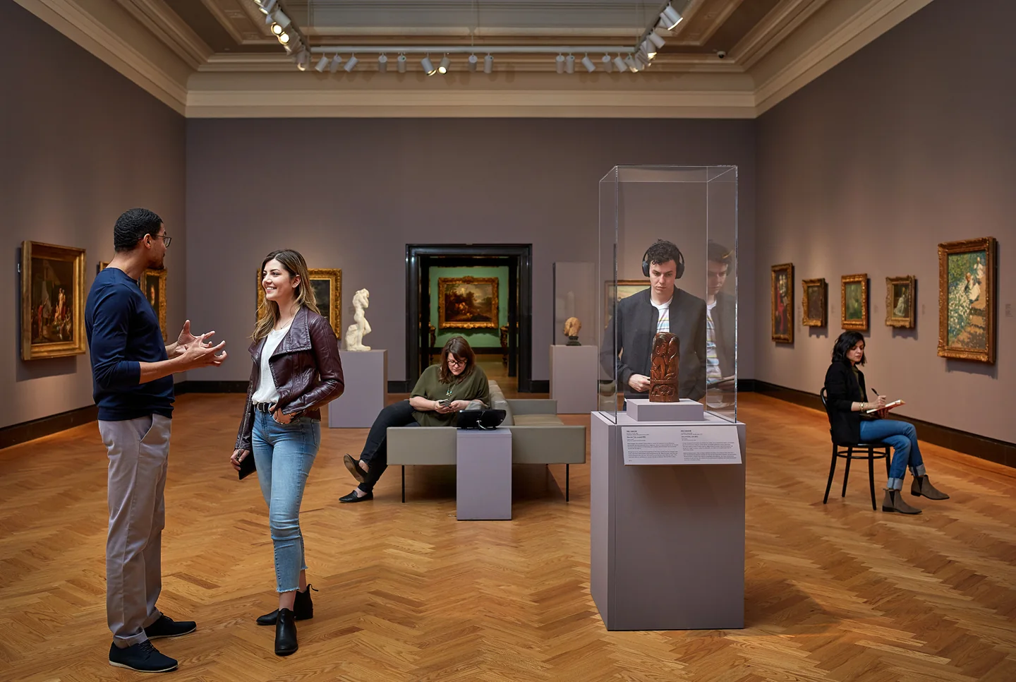 Visitors talking and looking at art in an AGO gallery