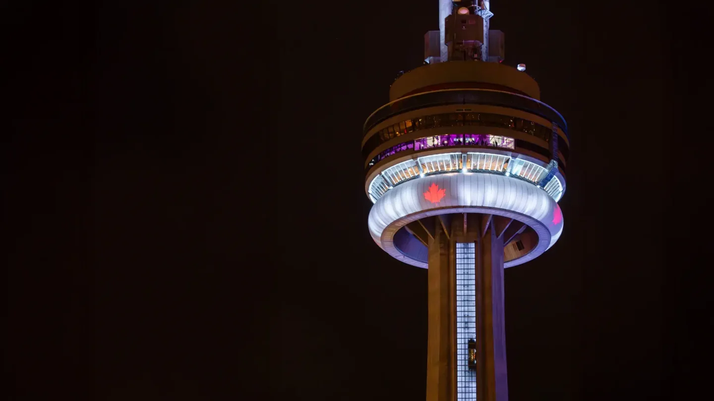 The top of the CN Tower illuminated at night
