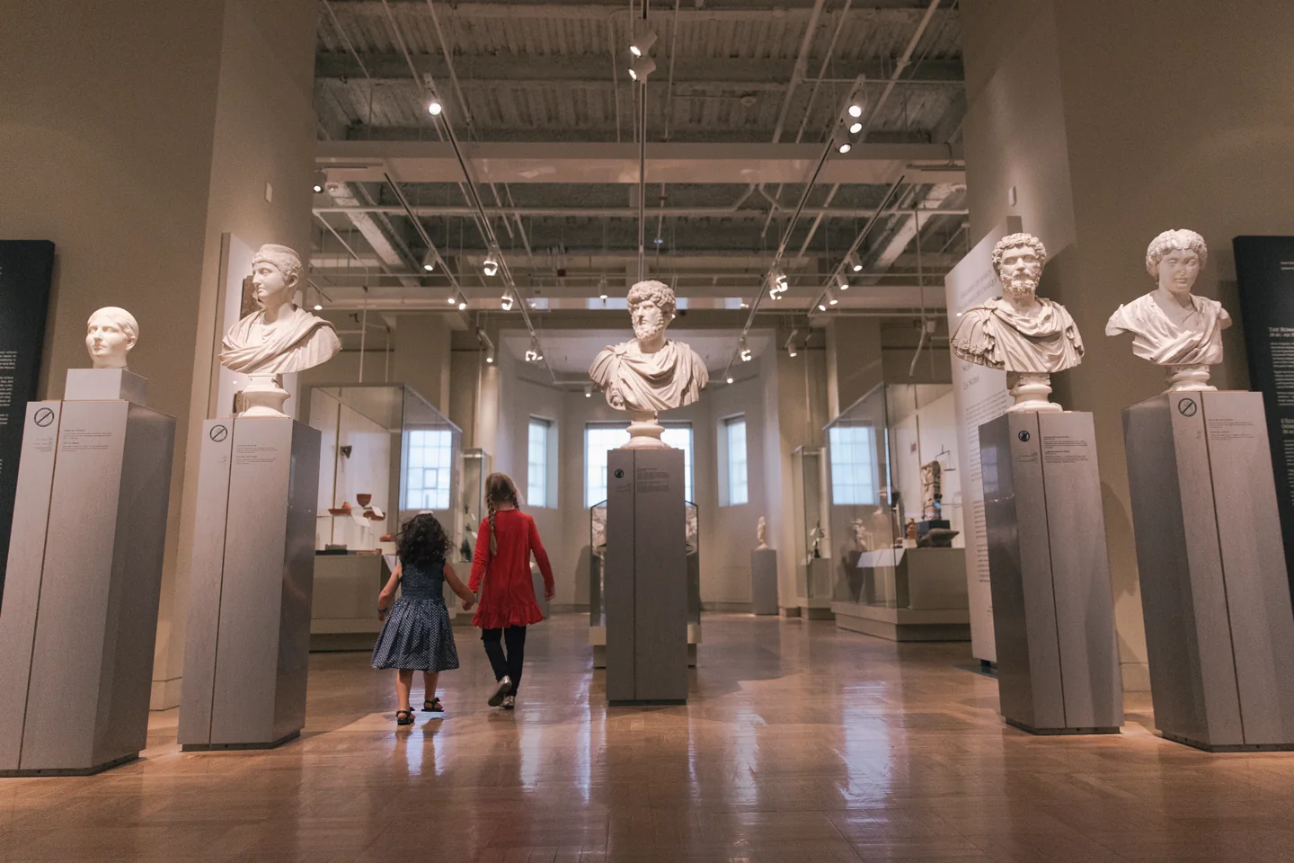 Visitors walking among Roman sculptures at ROM