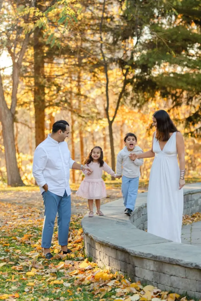 A family beneath autumn leaves at Humber Arboretum