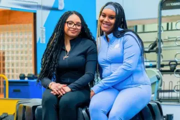 TMU students Cami Rabia and Abbygail Baker-Douglas sitting together in a workout room