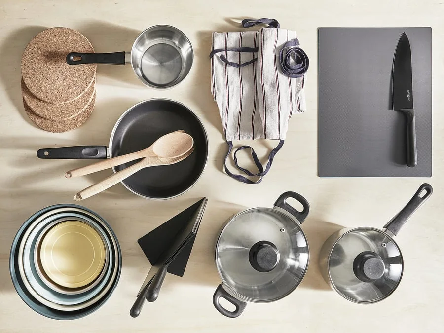 Pots, pans, dishes and utensils laid out on a worktop