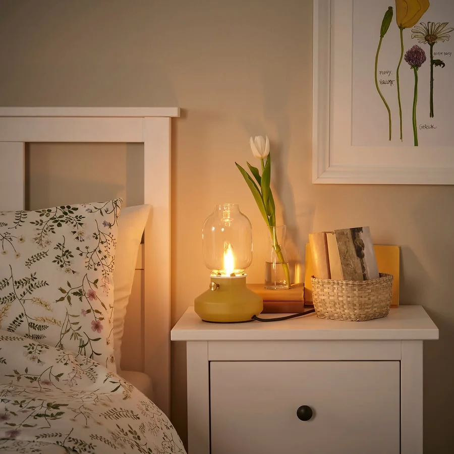 A small yellow lamp on a bedside table