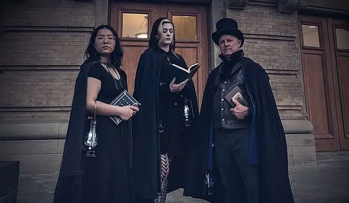 Three costumed tour guides at a University of Toronto building