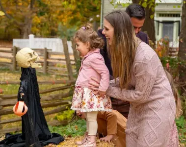 A woman and small child beside a Halloween display at the Village at Black Creek