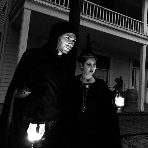 Two guides holding lanterns at the Village at Black Creek