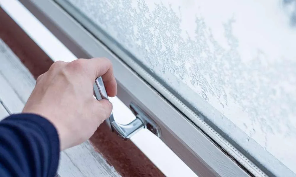 A hand checks a window latch.