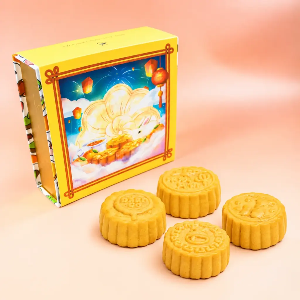 Four baked Daan Go mooncakes beside their closed gift box