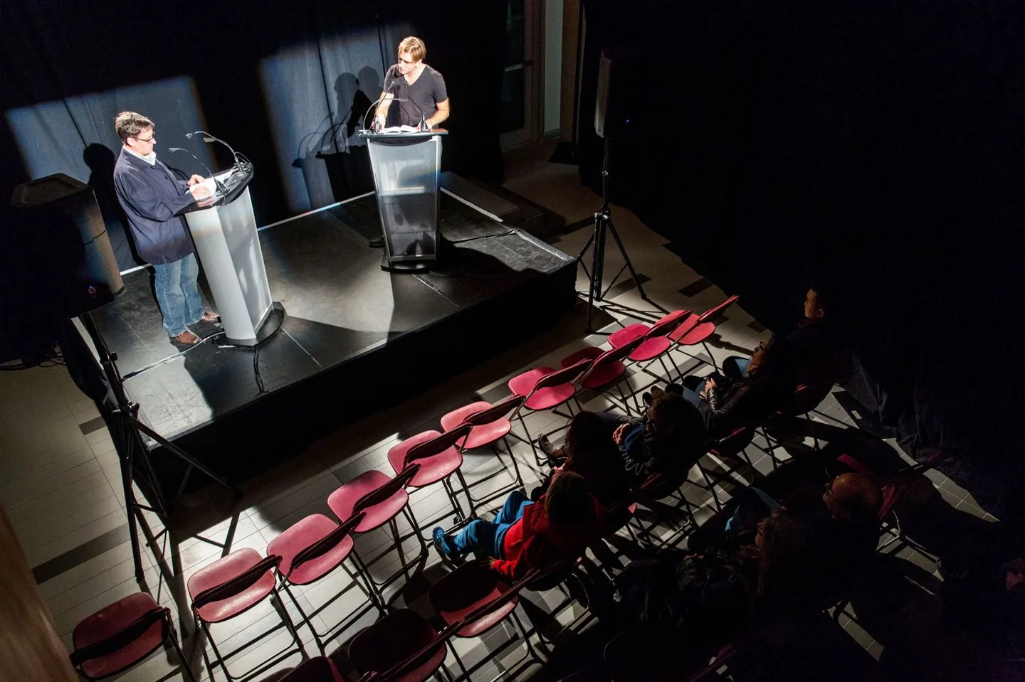 Two performers facing each other at podiums in Everything and Nothing