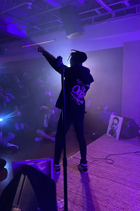 A R.I.S.E. performer on a purple-lit stage