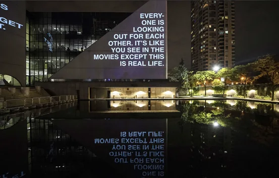 Words from Hiba Abdallah’s artwork projected onto a building at night in 2018