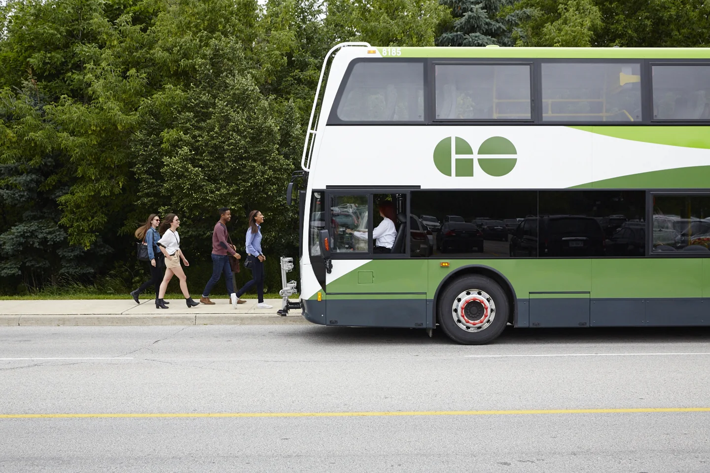 A GO double-decker bus beside a campus walking route.