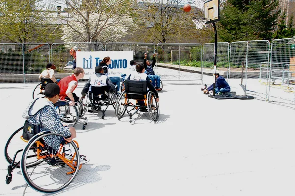 Playing wheelchair basketball game at the outdoor court.