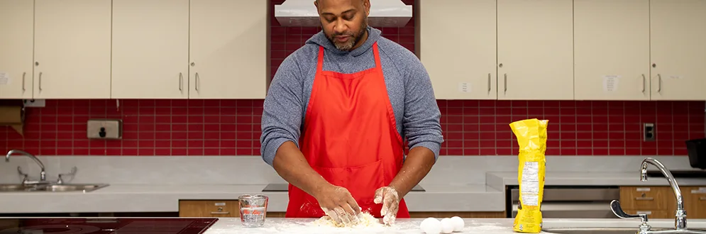 A cooking class participant working with flour.