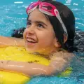A girl swimming with a kickboard.
