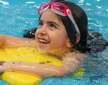 A girl swimming with a kickboard.