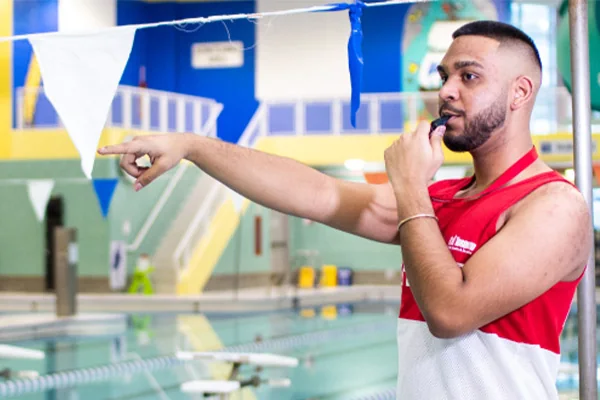 A lifeguard is whistling at the indoor pool
