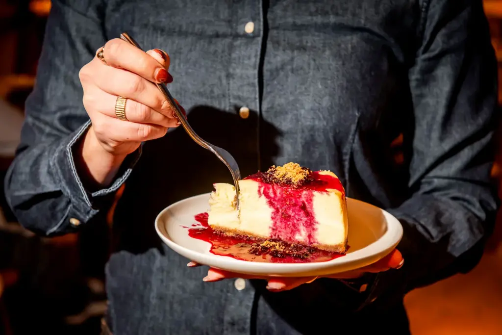 A diner taking a spoonful of cheesecake at The Joneses