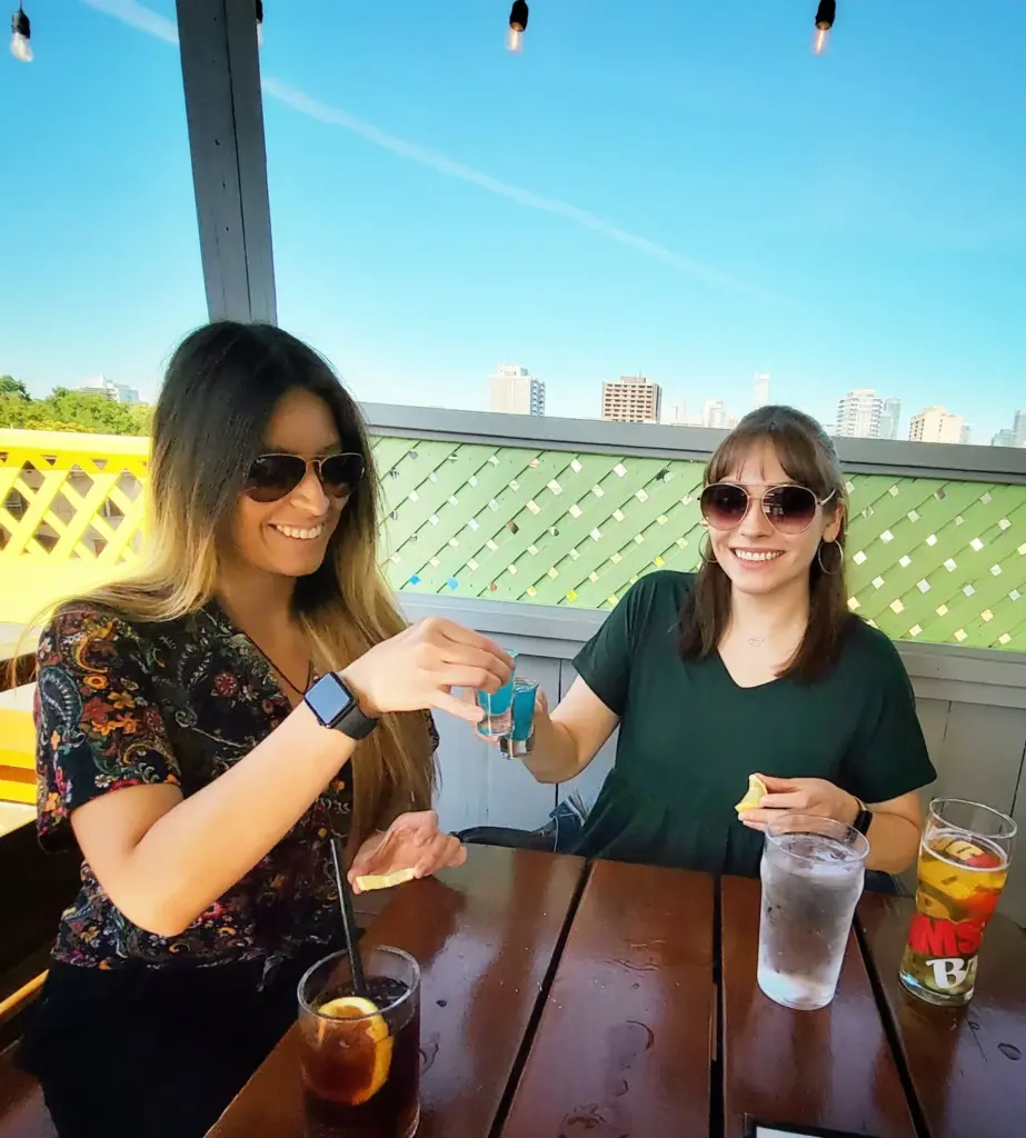 Two women sitting with drinks on the Paupers patio