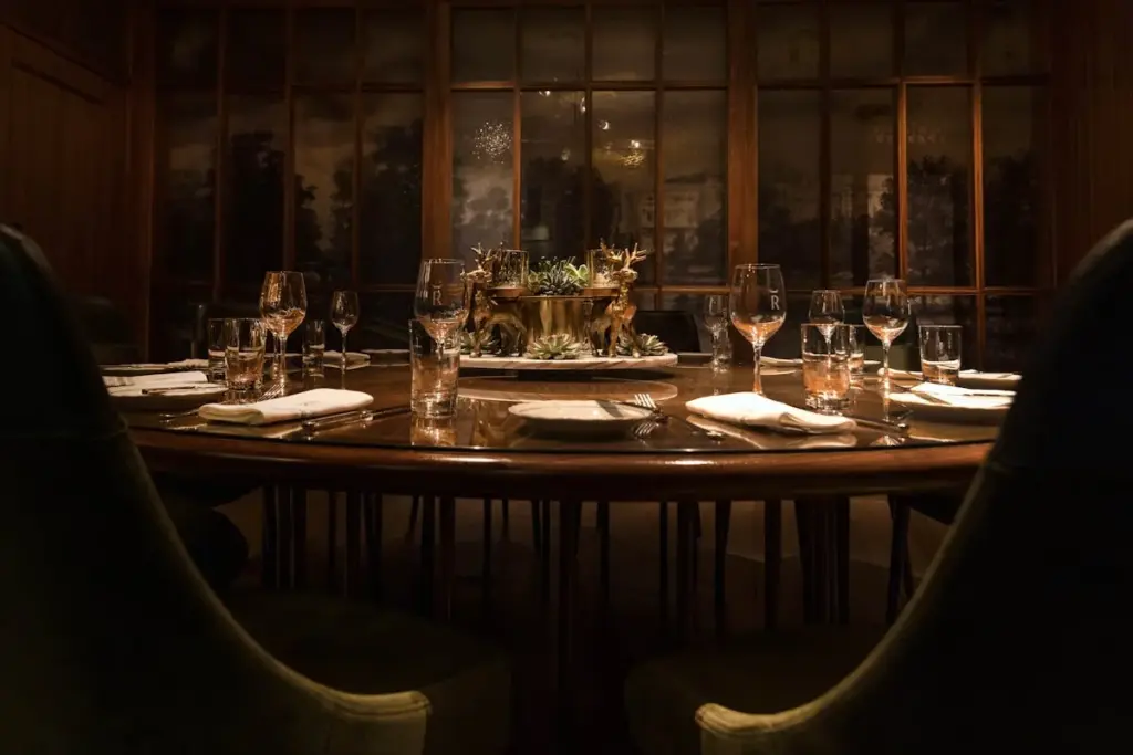 REIGN dining room with set tables and dark wood walls