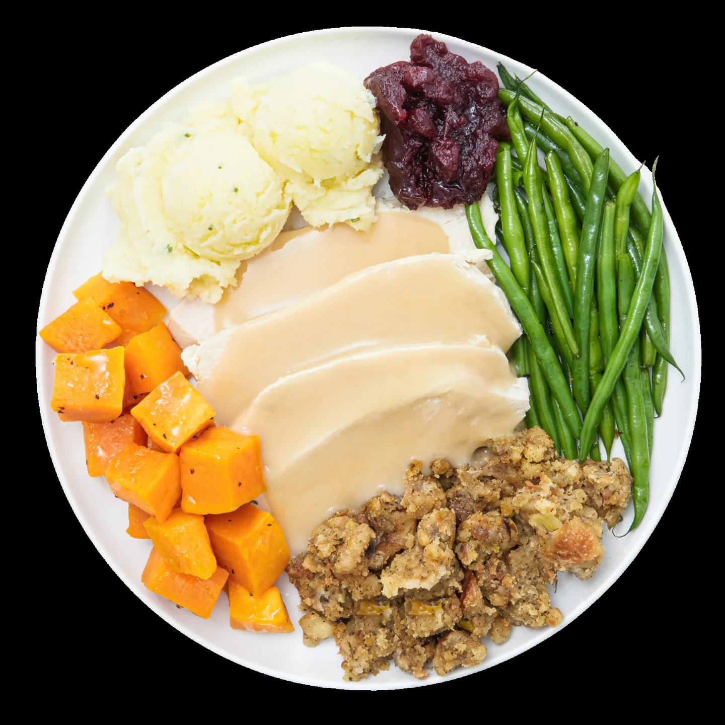 Turkey, gravy, stuffing, potatoes, beans and squash on a plate