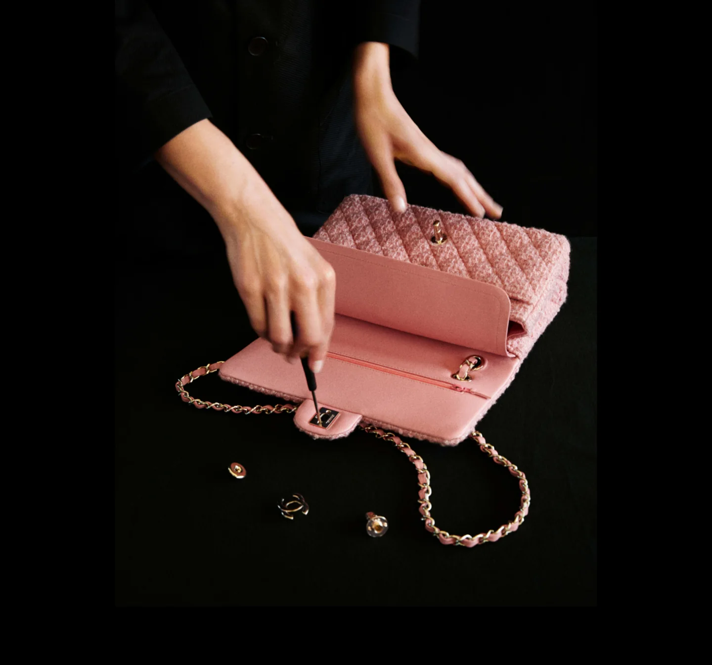 Hands examine a pink Chanel handbag