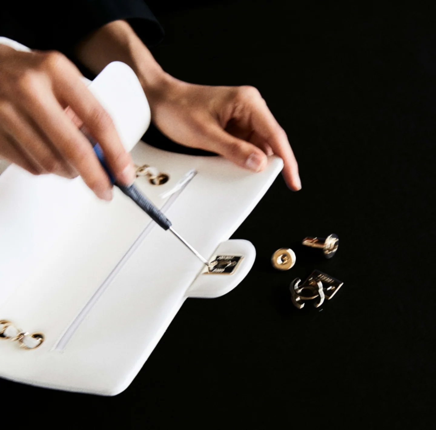 An open light-coloured Chanel bag reveals its interior and fittings
