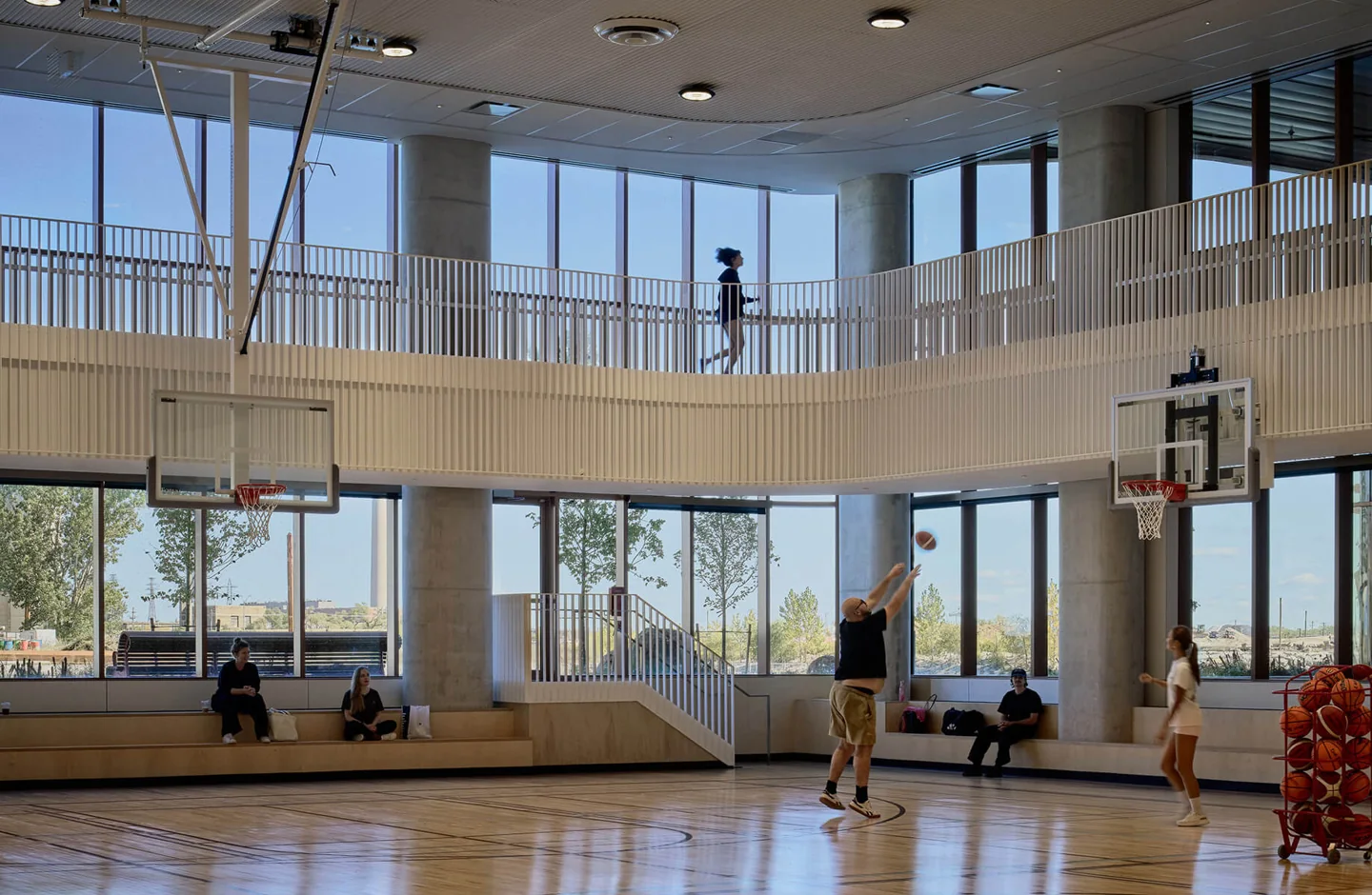 People practise basketball beneath the running track at East Bayfront Community Recreation Centre