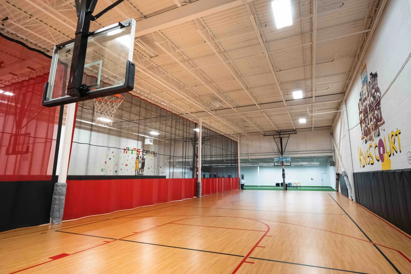 A wooden basketball court and divider net at Kings Courts Etobicoke
