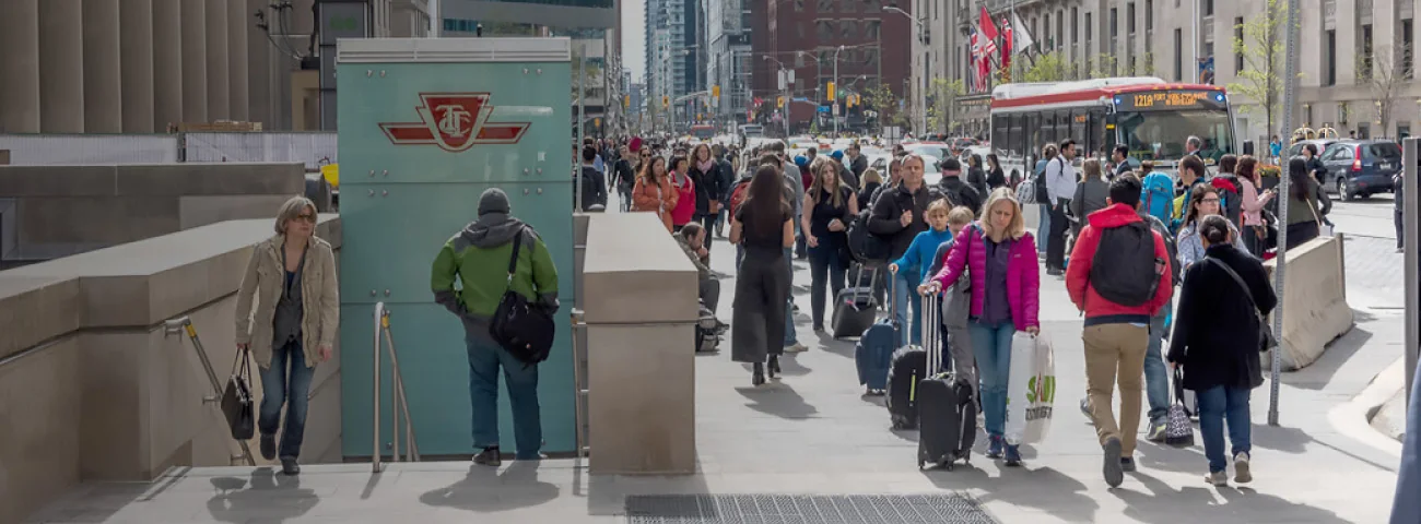 People with bags and suitcases pass Union Station’s TTC entrance on Front Street