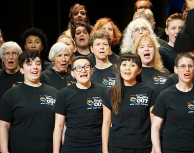 Singing Out members sing together in black choir T-shirts