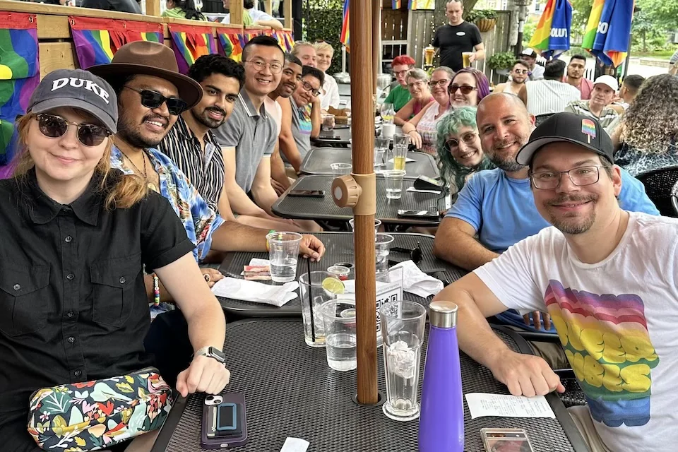 A group from Singing Out sits together around an outdoor table