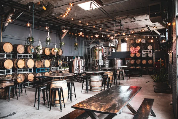 Tables, stools and string lights inside the Blood Brothers taproom