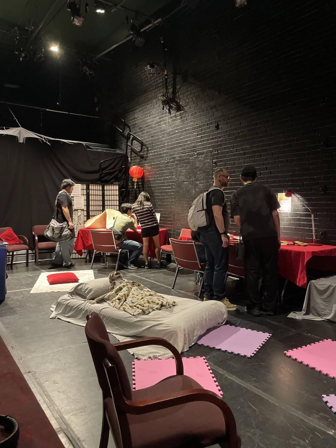 People resting and talking among chairs and cushions at Theatre Passe Muraille in 2025