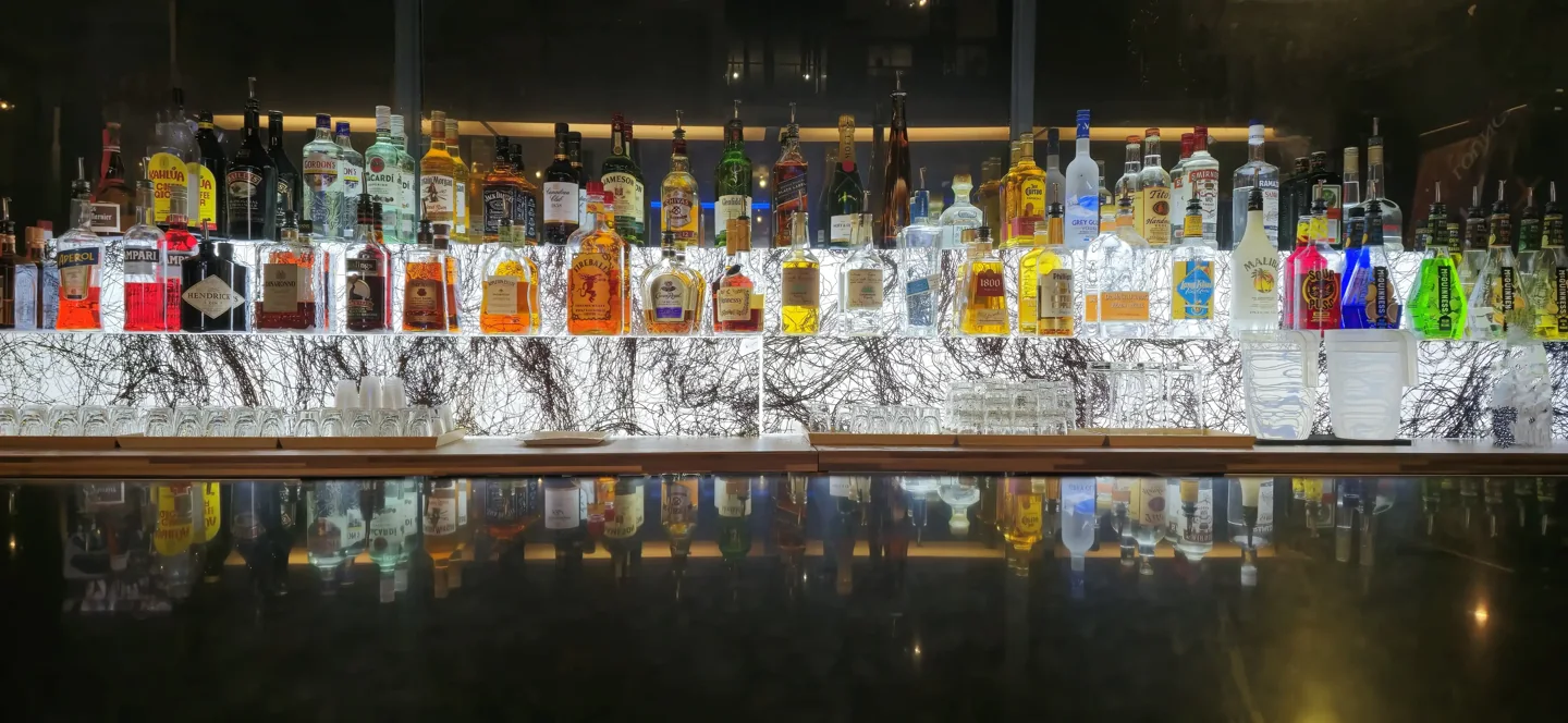 Bottles displayed behind the bar at Bar+