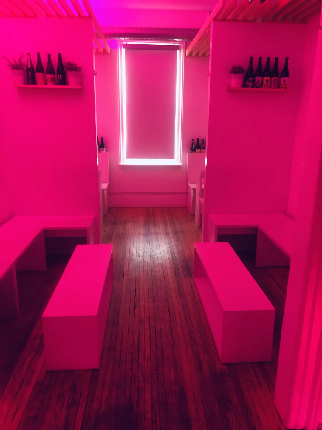 Pink booth seating and a narrow aisle at Bathurst Local