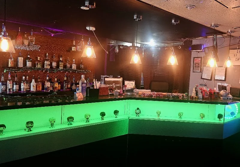 Bottles and green accent lighting behind Echo Bloor’s bar