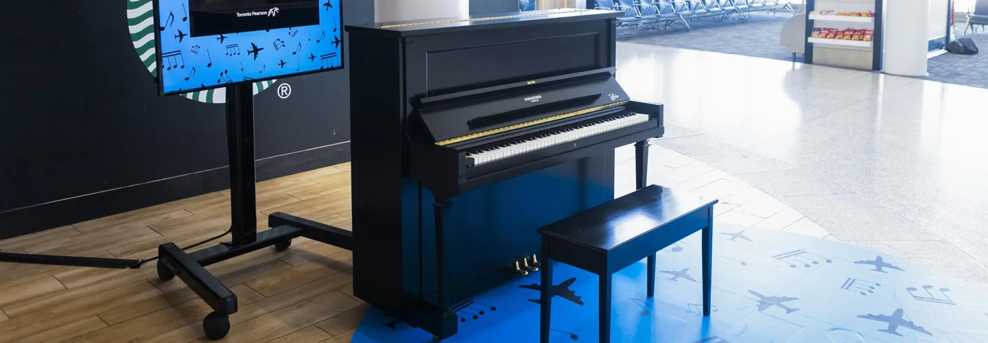 Pearson’s black upright Nordheimer piano and bench in an airport terminal