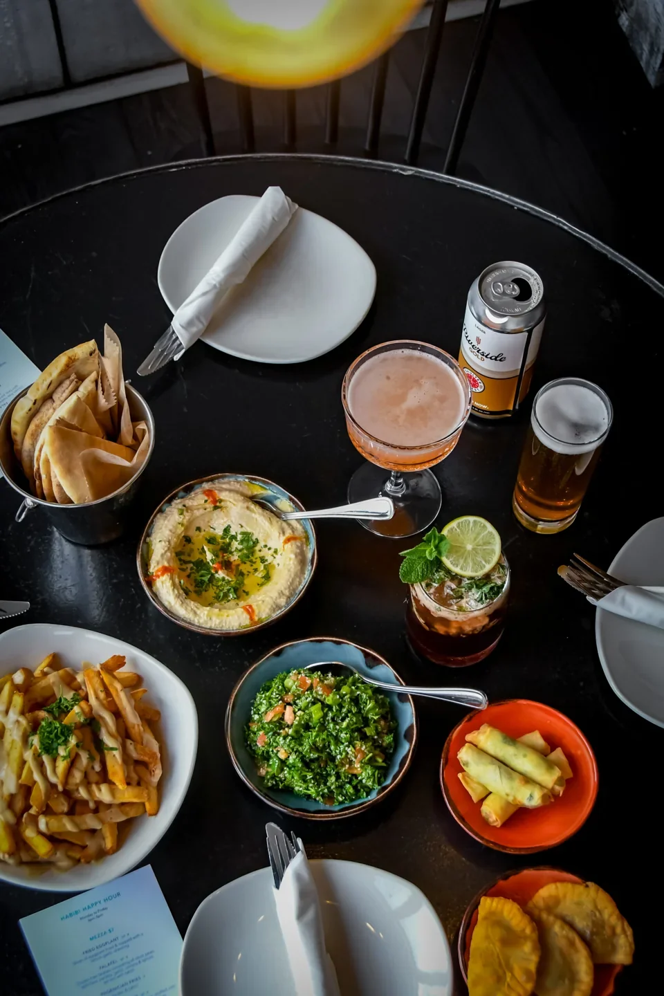 Several Tabule dishes, dips and drinks on a table