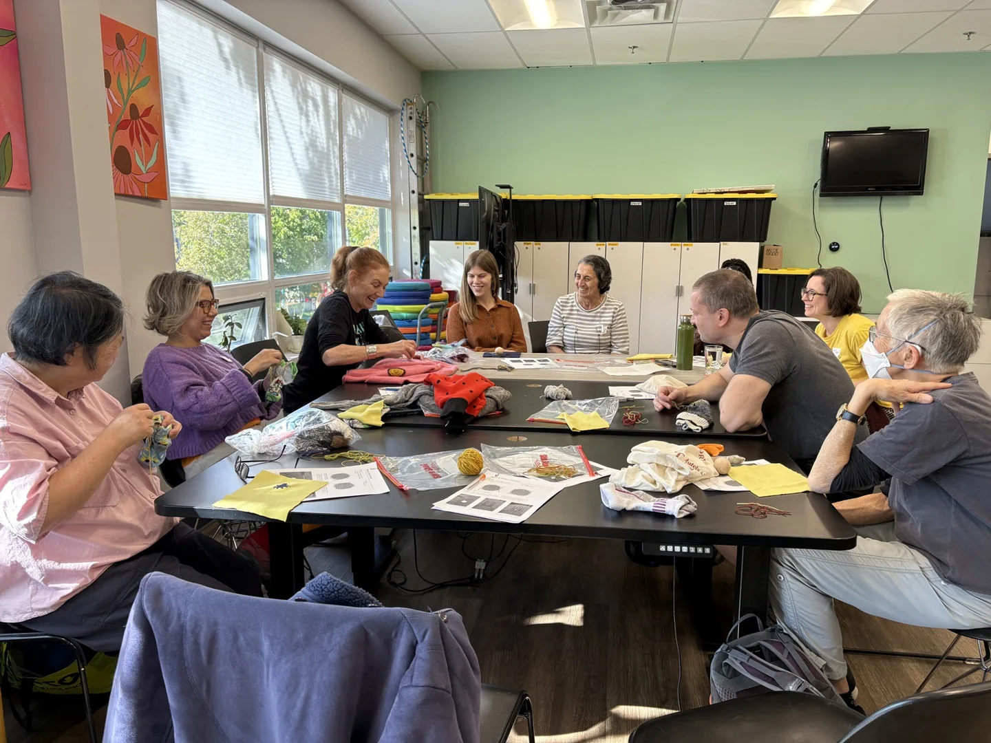 People mending clothes around a table at a Repair Café Toronto session