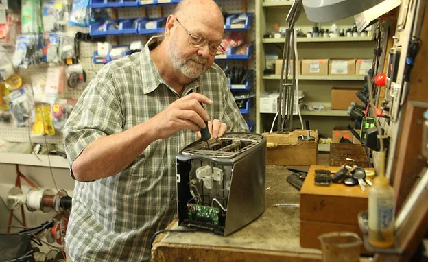 A man works on an old toaster at Butler’s Appliance Service