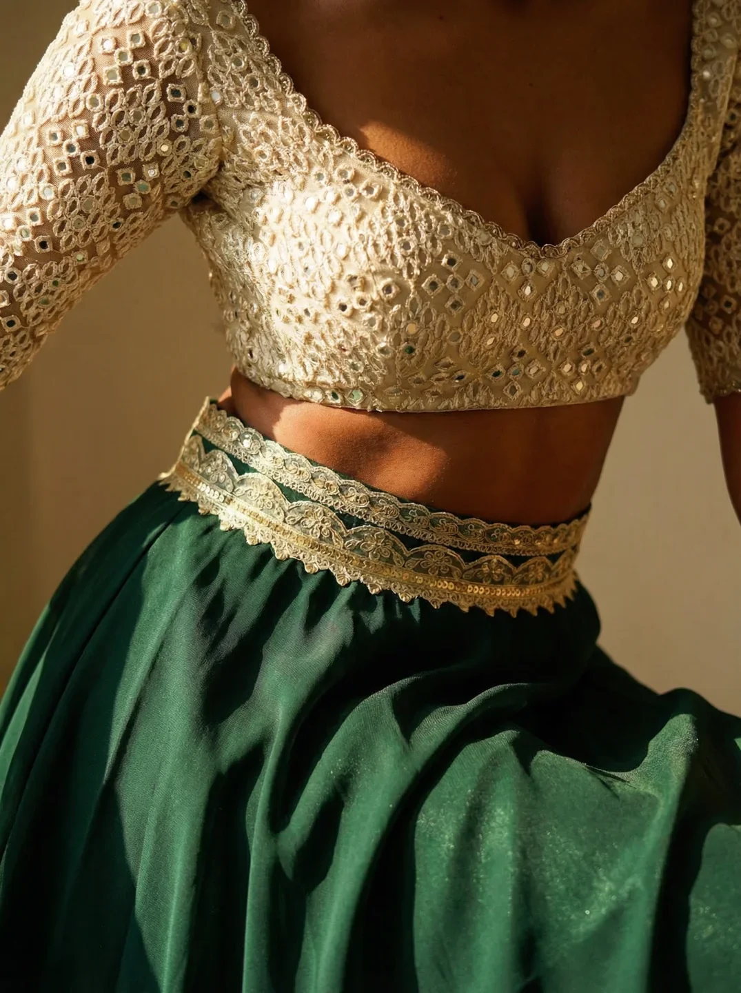 Detail of an embellished gold blouse with a green skirt