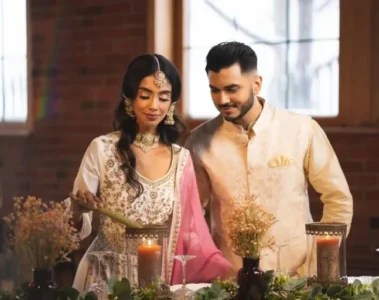 Two people wearing embroidered South Asian occasion outfits in Chandan Fashion’s photograph
