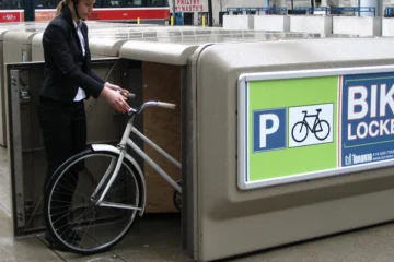 A cyclist places a bicycle in a City of Toronto bike locker